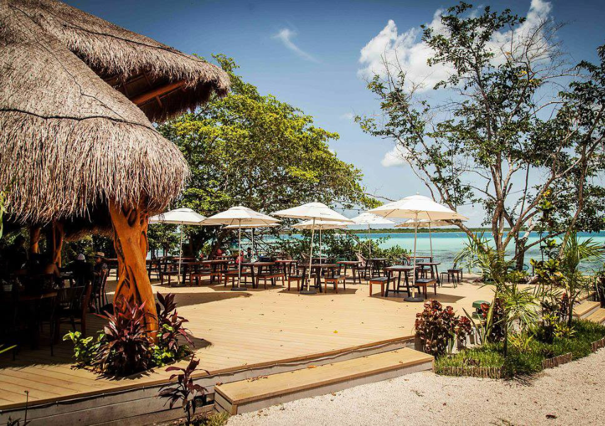 palapa cabanas overlooking the Bacalar Lagoon at the restaurant La Playita in Bacalar, Quintana Roo, Mexico near Tulum.