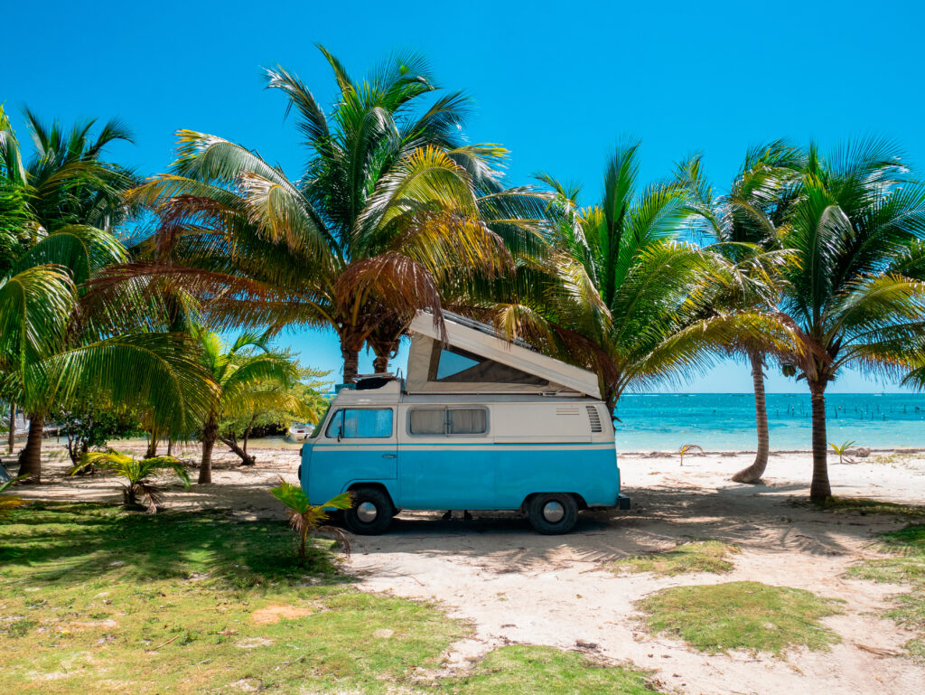 old restored VW bus van with window panels parked on the white sand beach of Mahahual, Mexico in the Riviera Maya